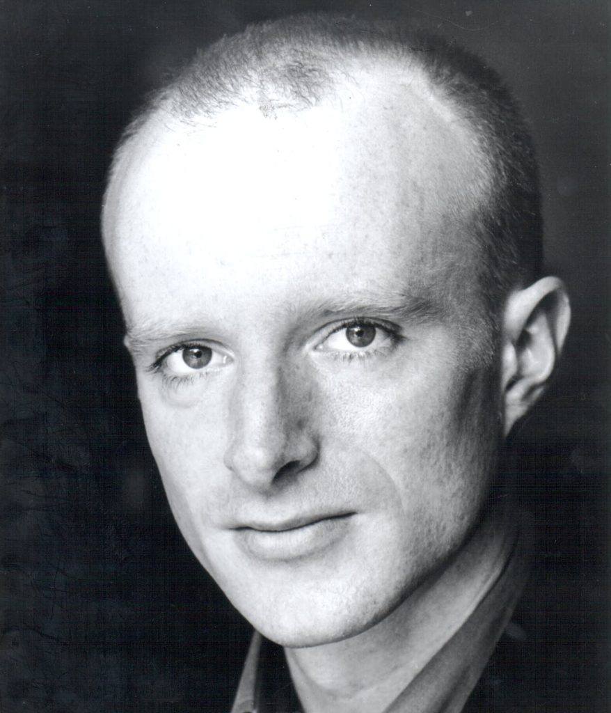 Headshot of a bald man looking straight at the camera, perfect for personal impact training.